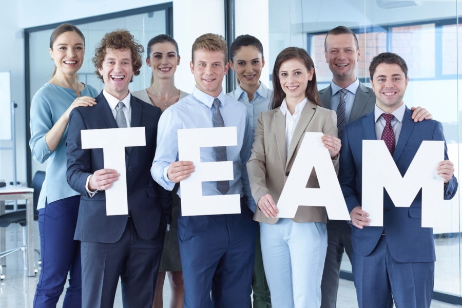 8 Verwaltungsmitarbeiter einer Klinik steht als Gruppe zusammen und halten die Buchstaben TEAM in die Kamera 8 Verwaltungsmitarbeiter einer Klinik steht als Gruppe zusammen und halten die Buchstaben TEAM in die Kamera